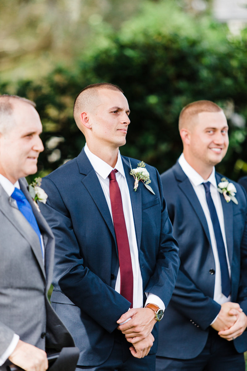 groom watching bride walking down the aisle