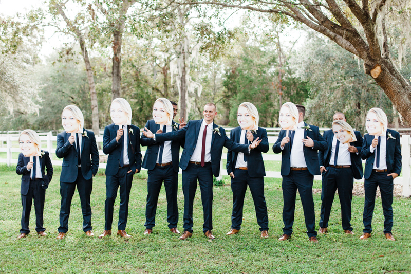 groomsmen holding faces of bride