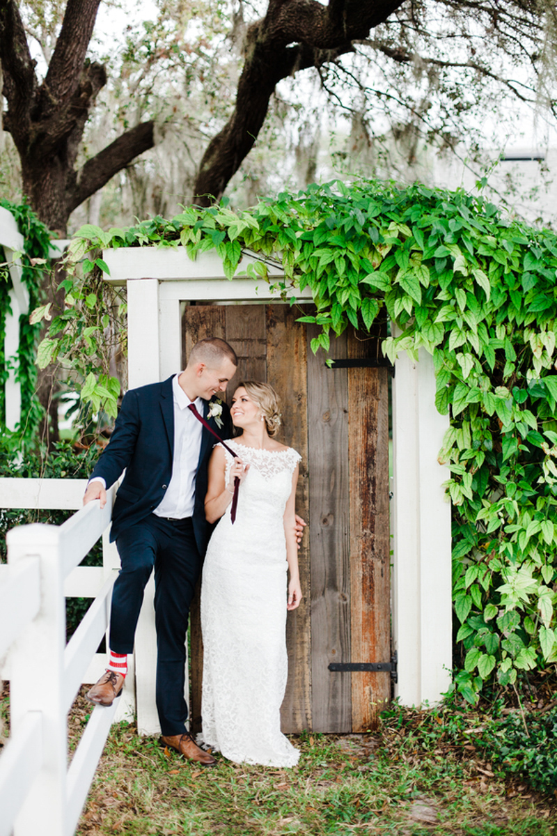 bride and groom standing in front of rustic door for Bramble Tree Estate wedding