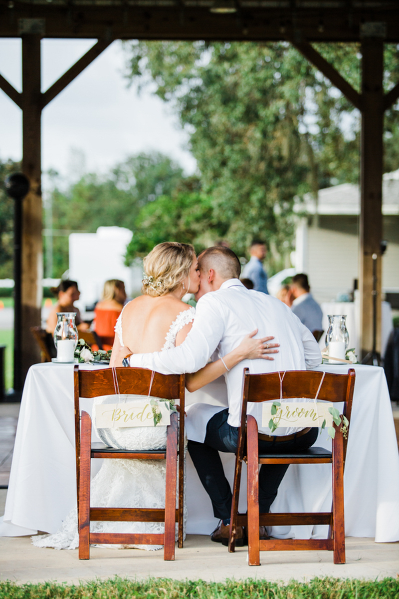 Couple kissing at sweetheart table
