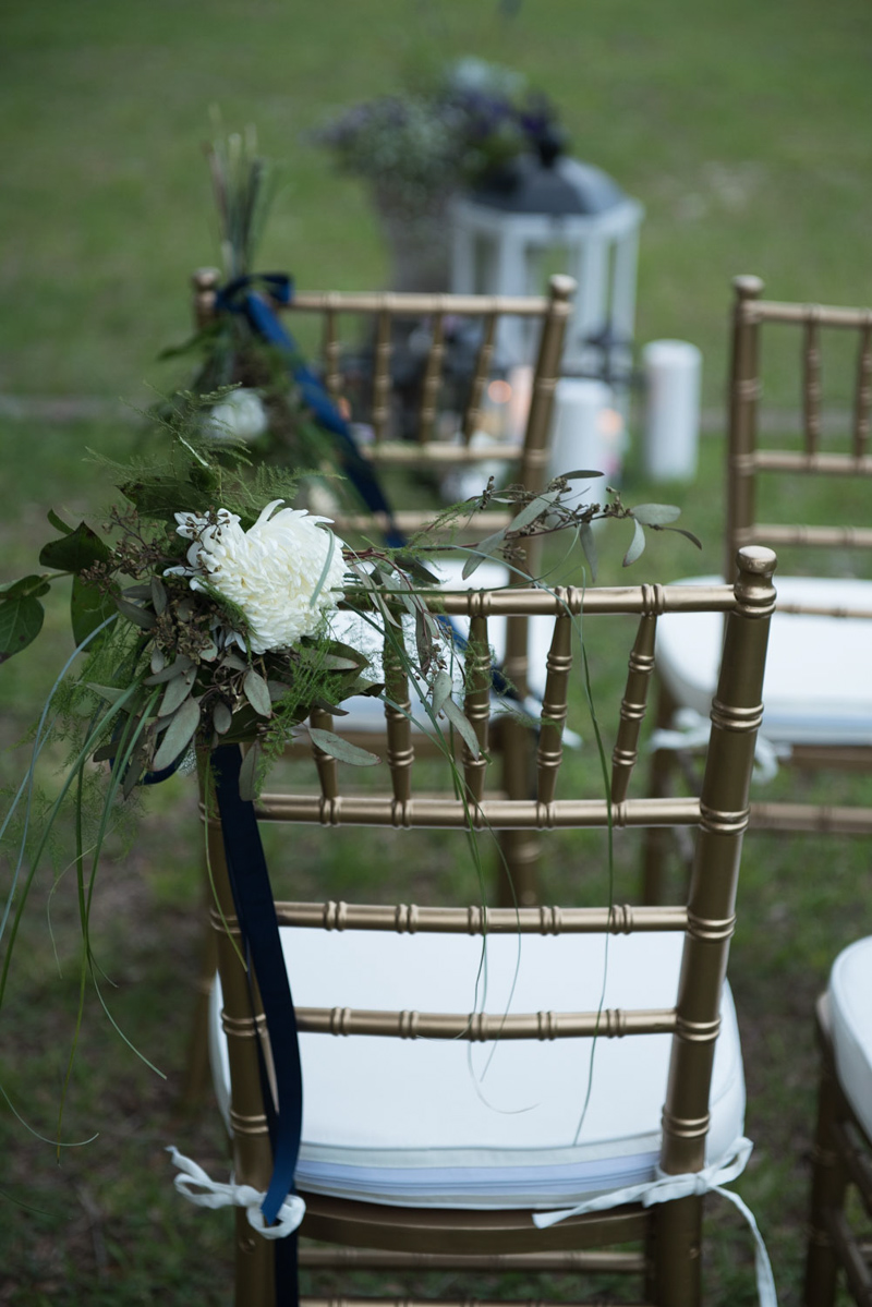 floral wedding ceremony pieces on gold chiavari chairs
