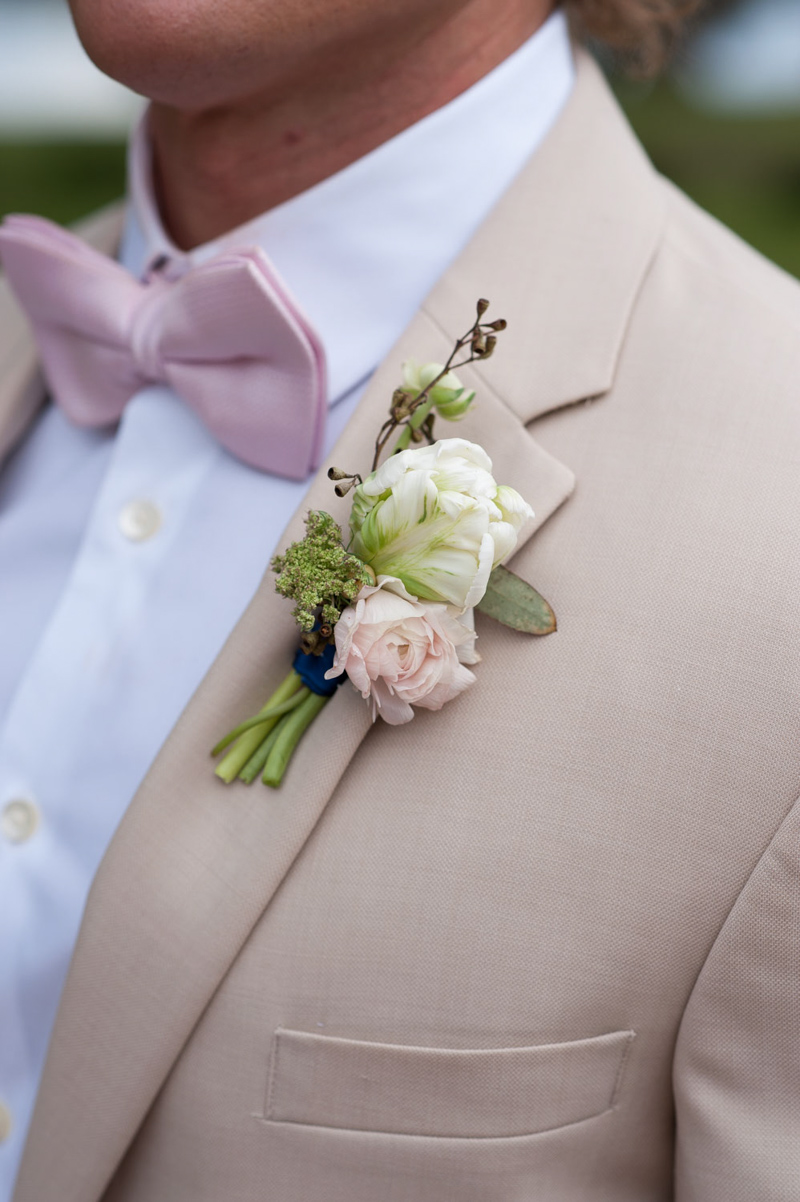 white and blush boutonniere on tan coat