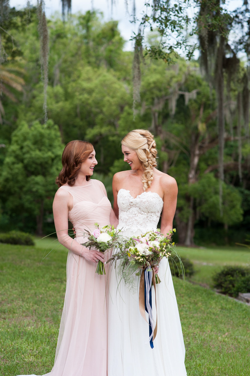 bride and maid of honor smiling at each other