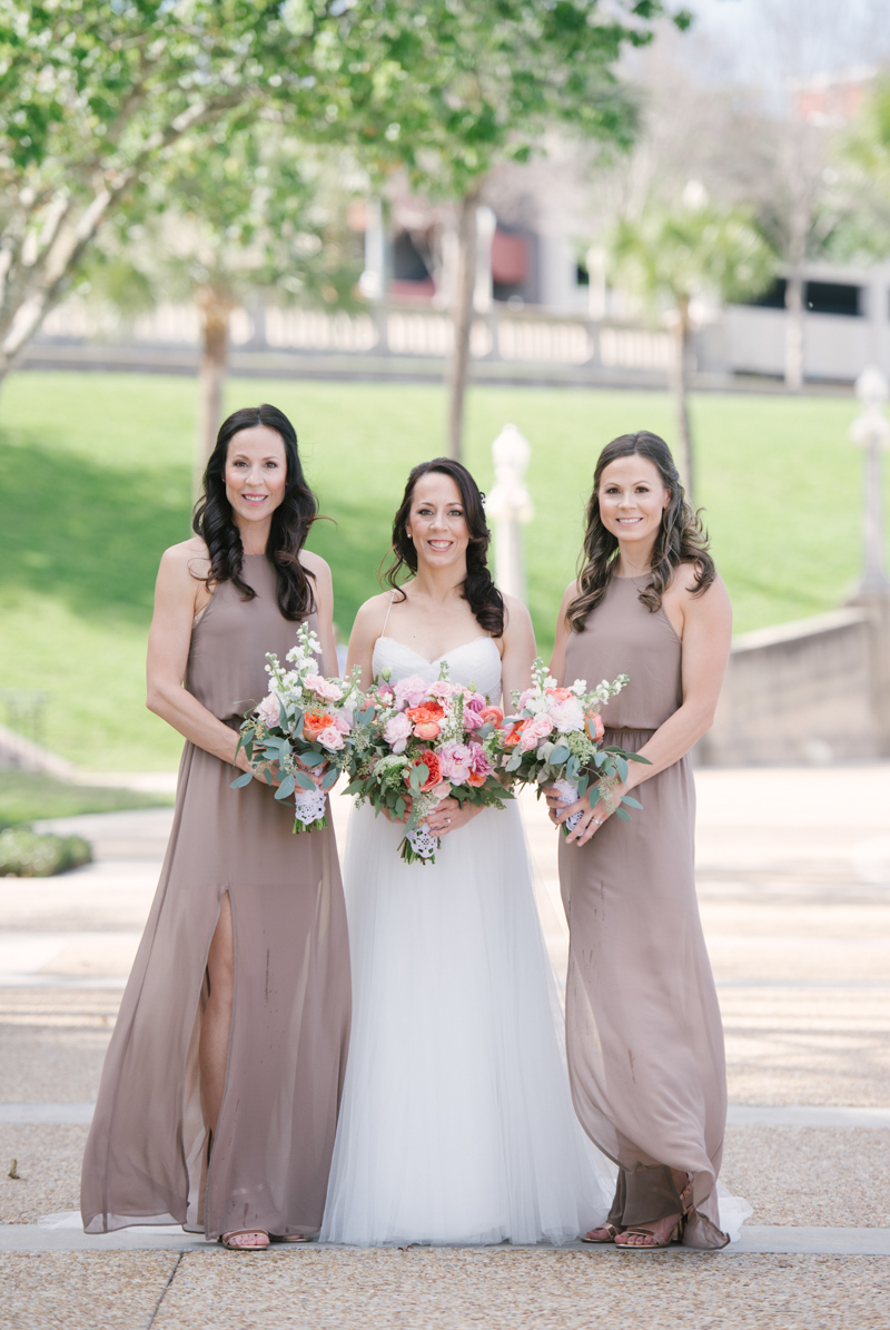 bridesmaids in taupe dresses next to bride