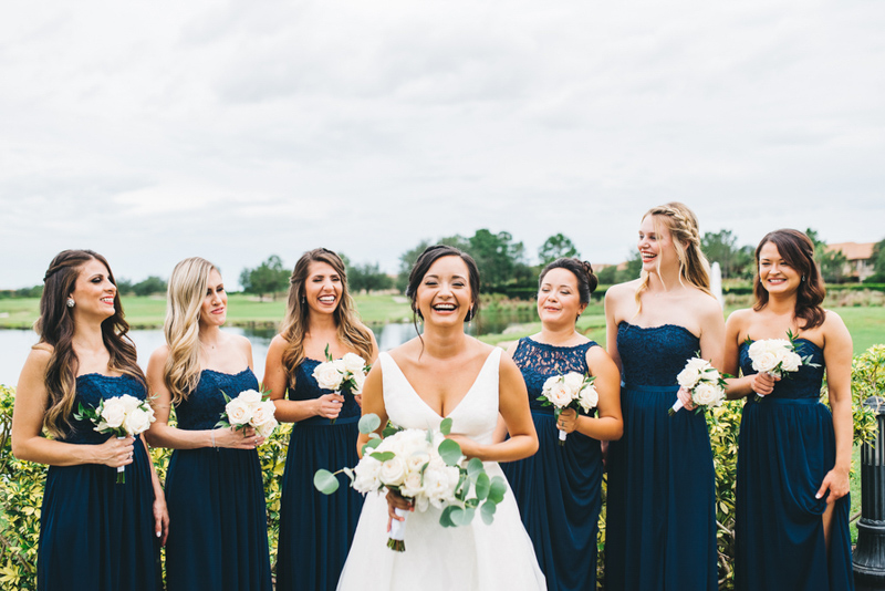 bridesmaids in navy dresses smiling with bride