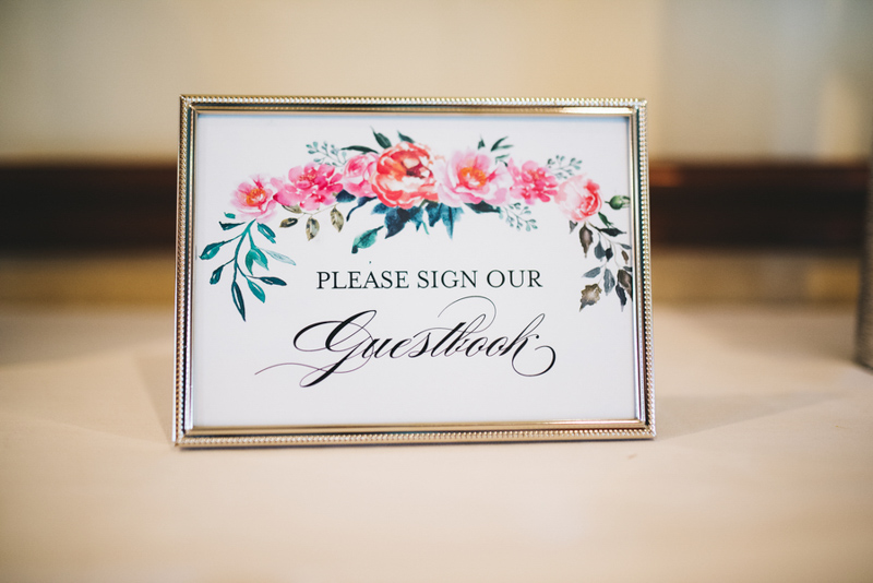 framed floral guestbook sign on table