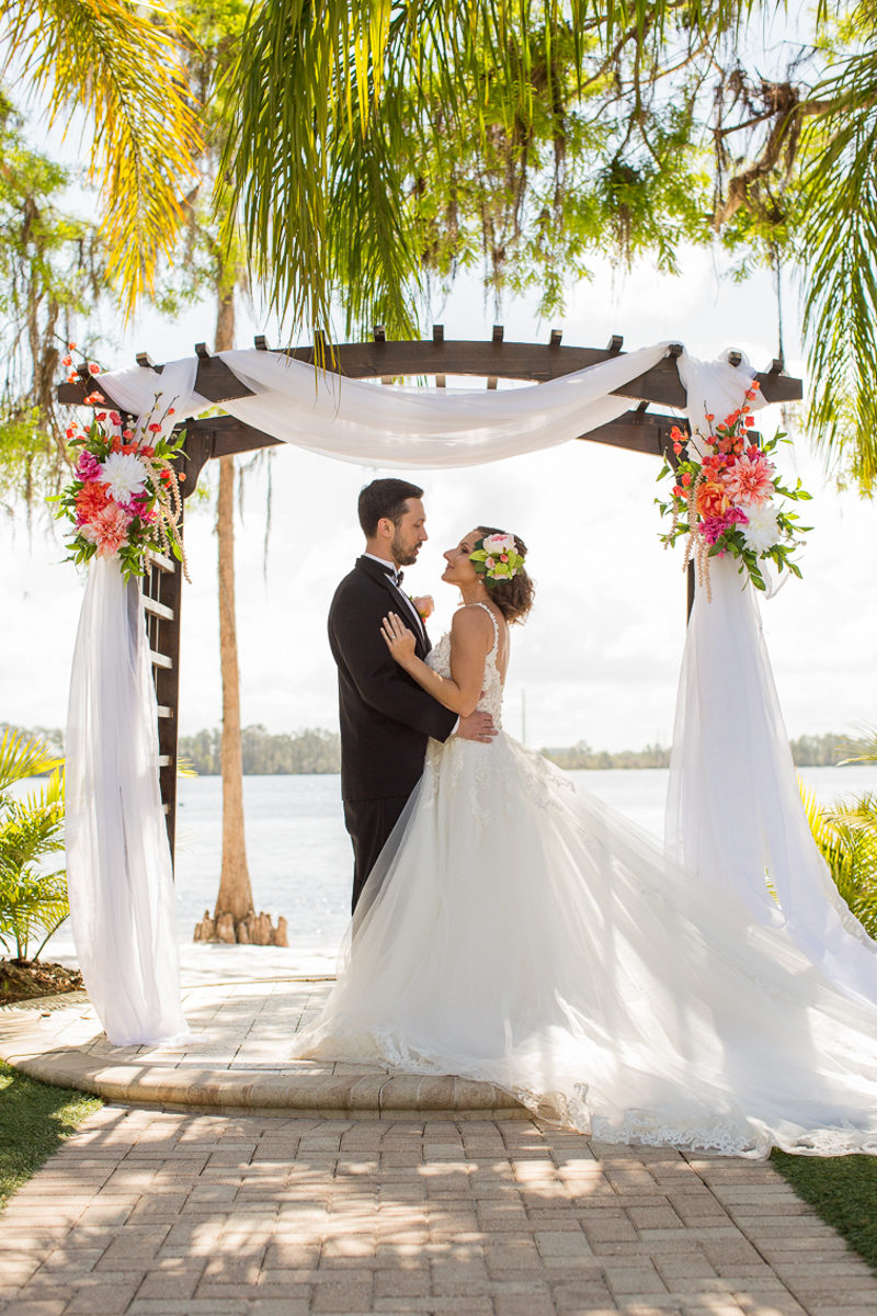 couple standing under wedding ceremony arch at Paradise Cove Orlando