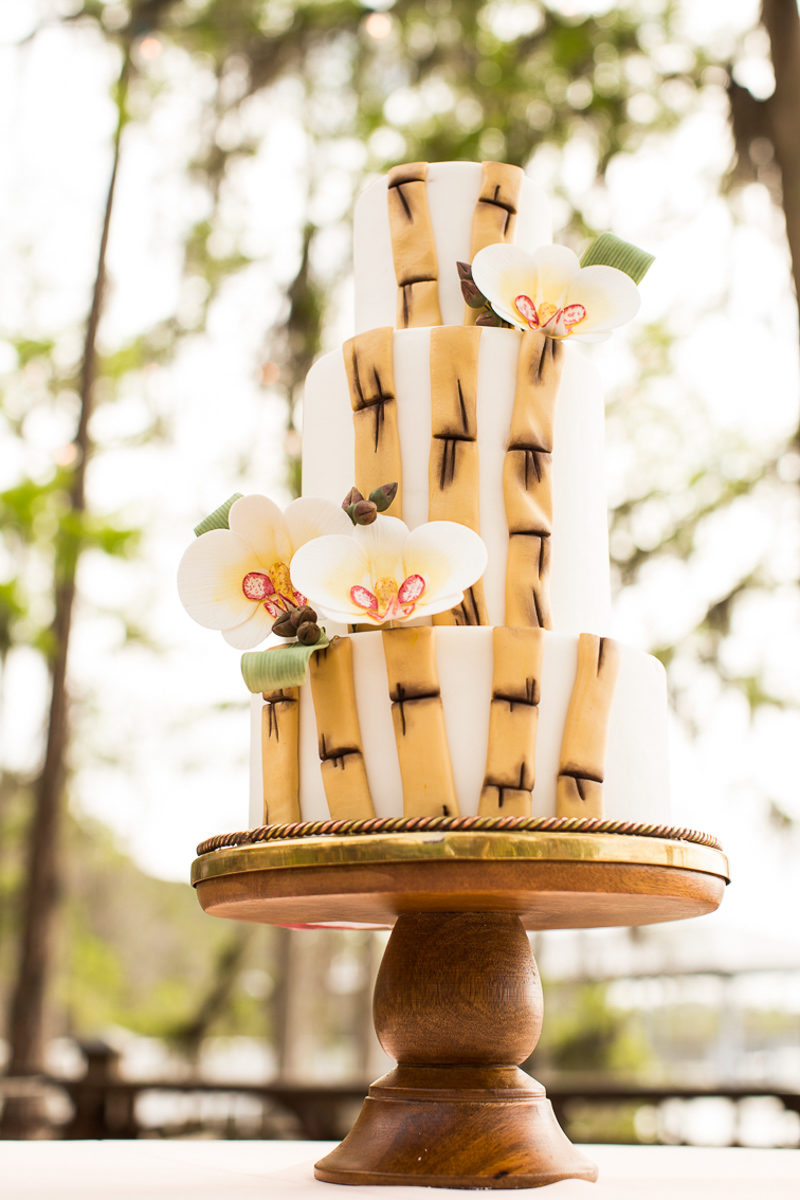 wedding cake on wood base with orchids and bamboo