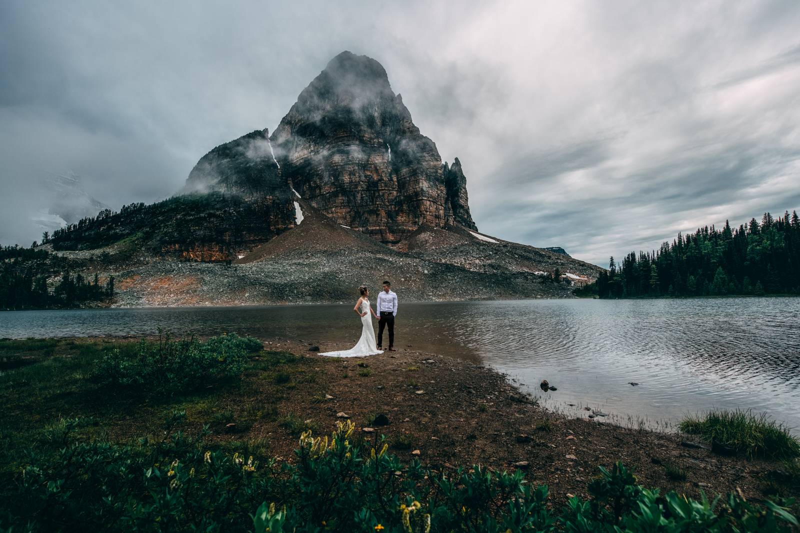 eloped couple holding hands in the mountains