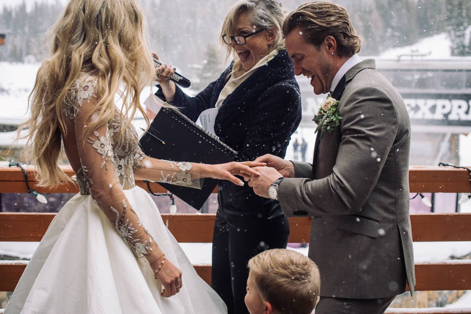 groom puts wedding ring on bride's finger