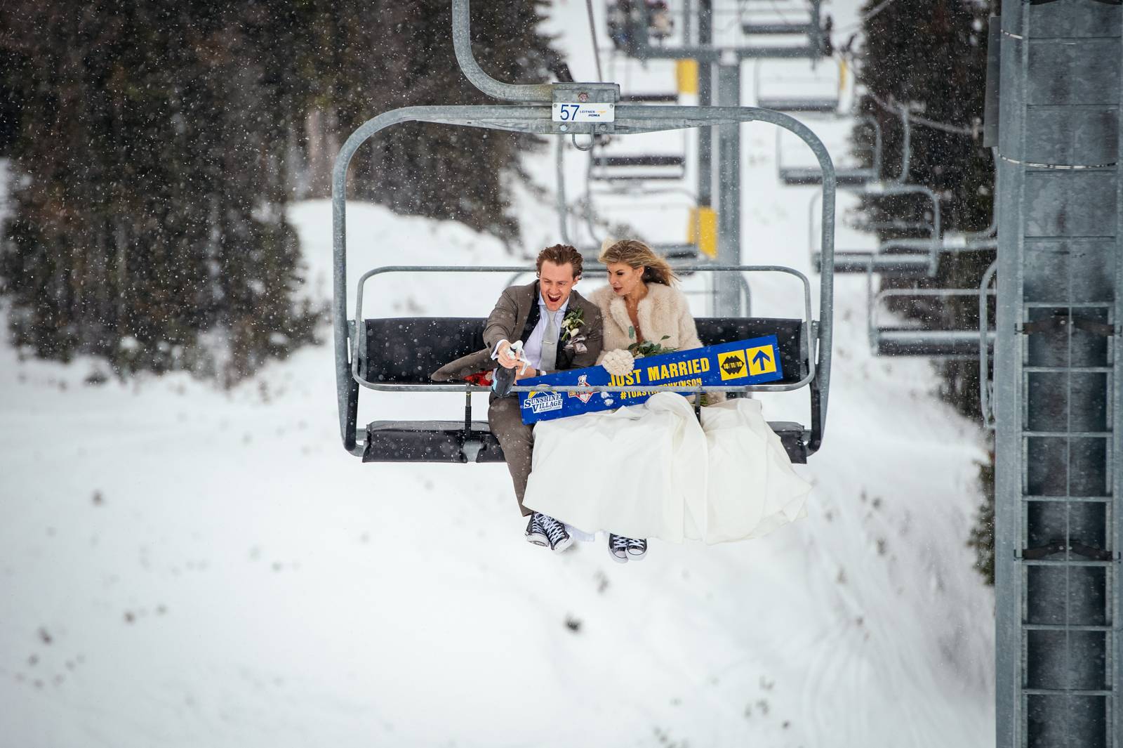 bride and groom on the ski lift at the Sunshine Village