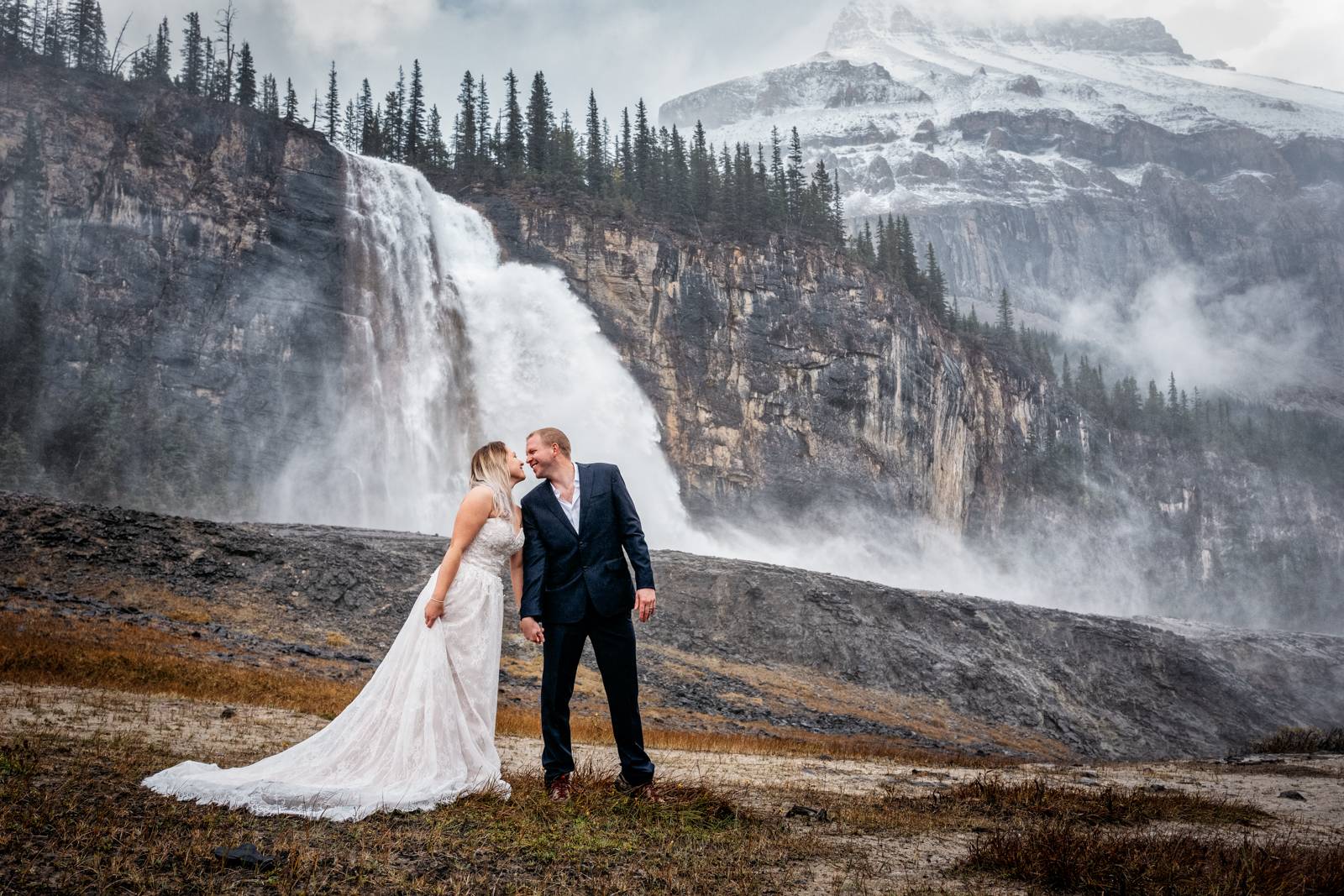 wedding couple kissing by the waterfall