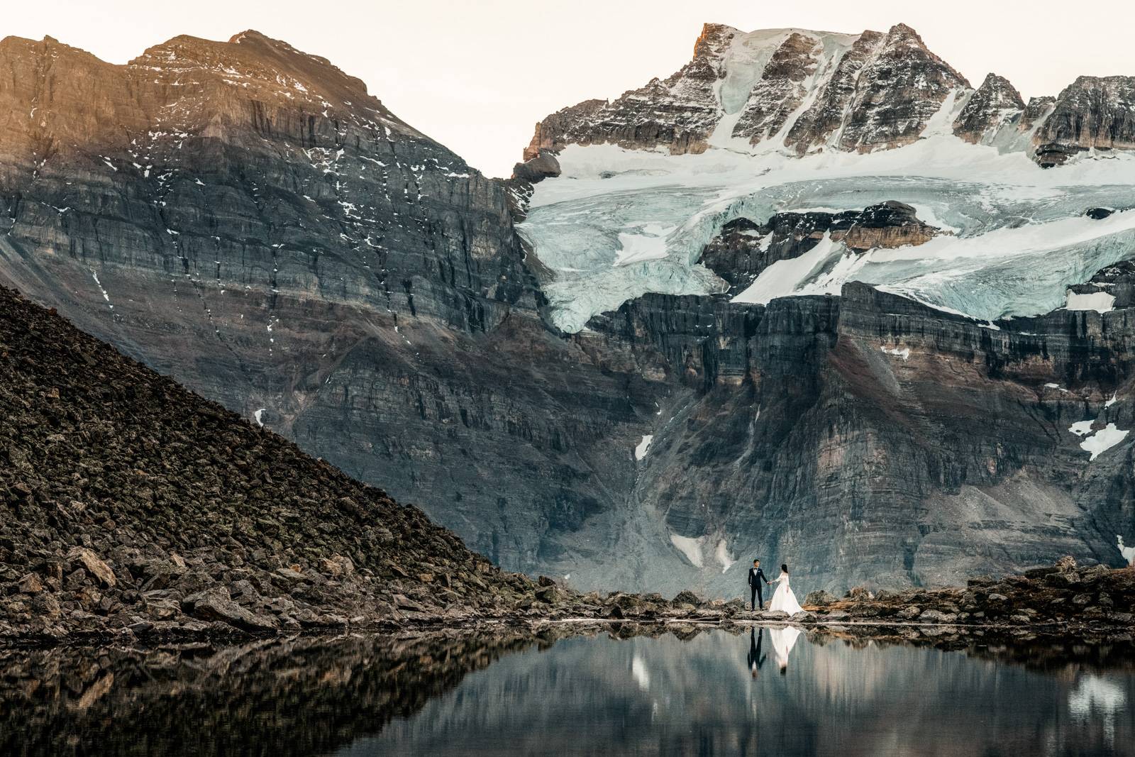 brigand groom holding hands in the mountains at the lake