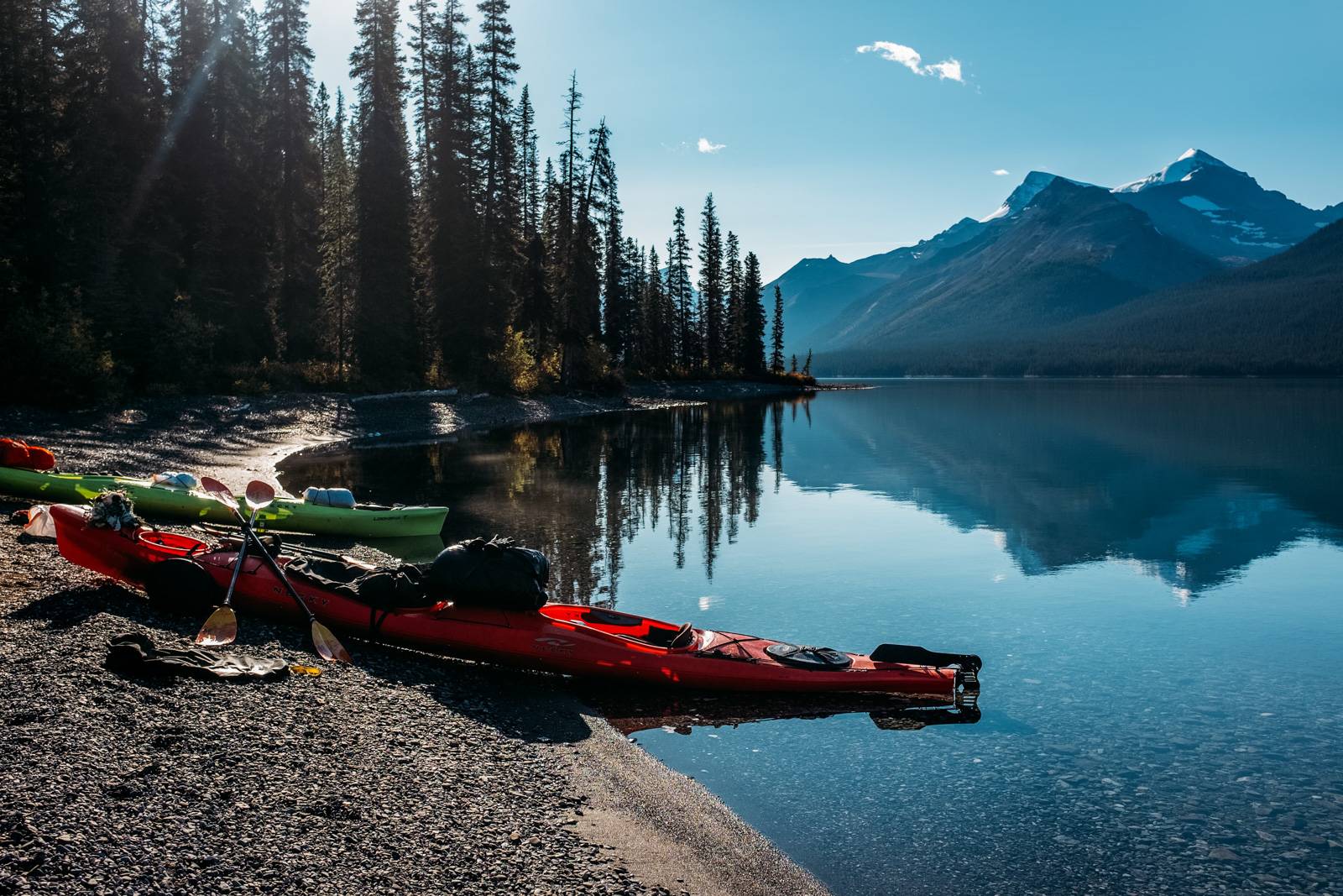 two kayaks on the shore of the lake