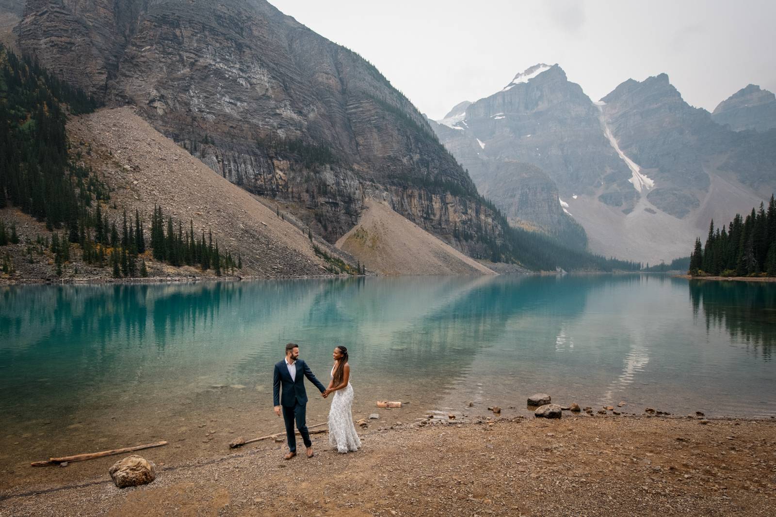 eloped couple holding their hands at moraine lake