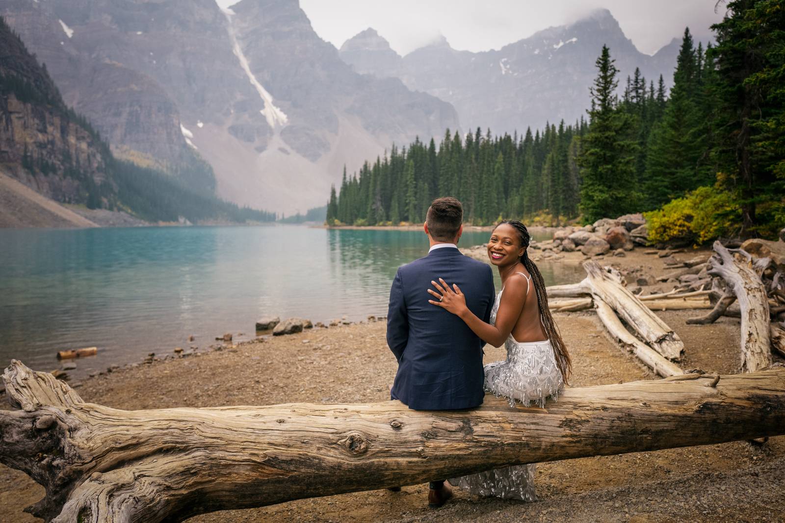 eloped couple sitting on the tree at moraine lake