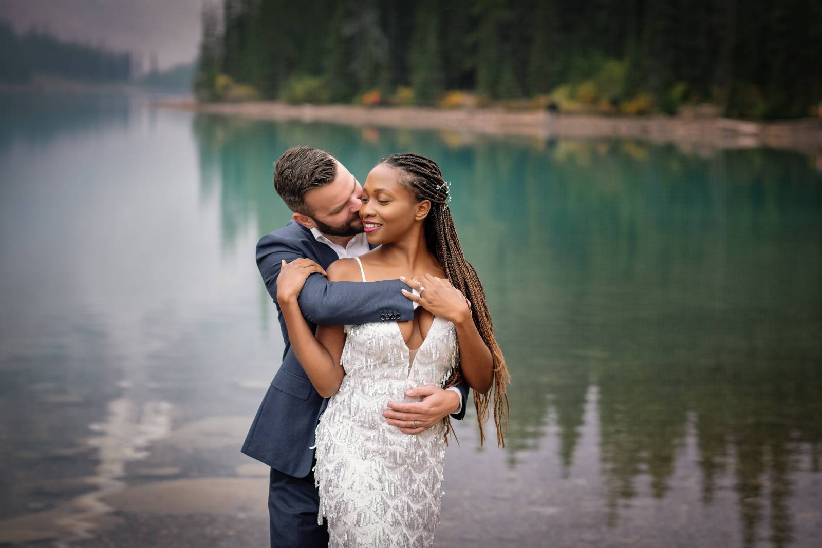 groom kisses bride at moraine lake