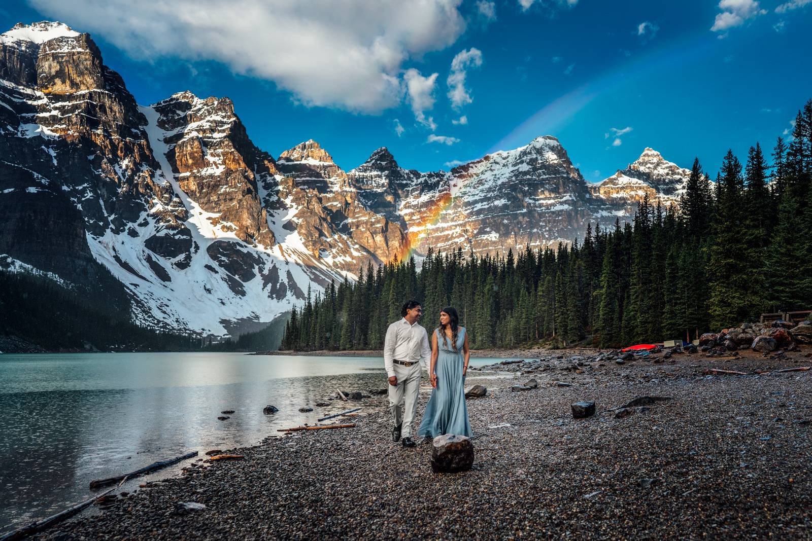 couple walking on the shore at moraine lake