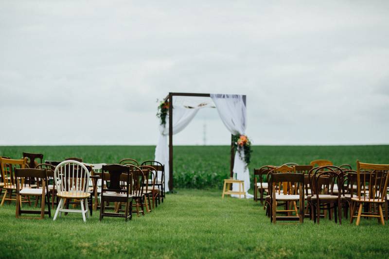 outdoor ceremony farm chic wedding vintage farm mix n match chairs chuppah ceremony arch arbor drapi