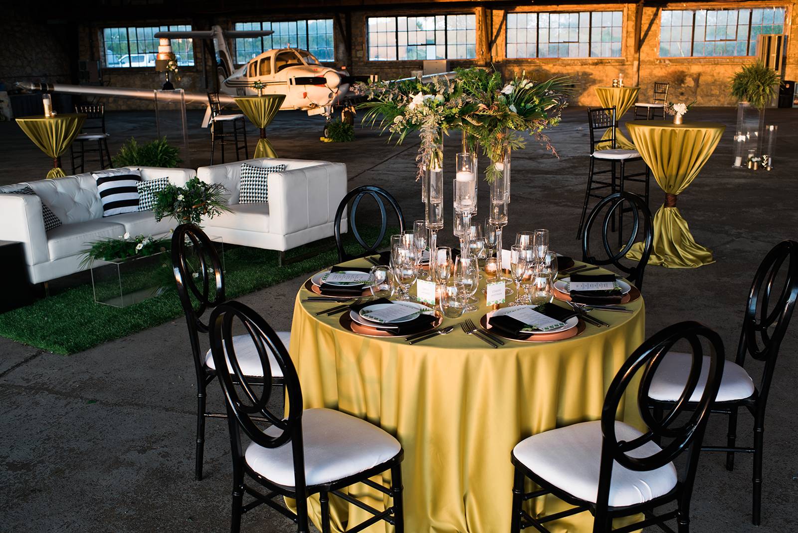 wedding reception design, green table linens, tall floral centerpieces, black specialty chair rental