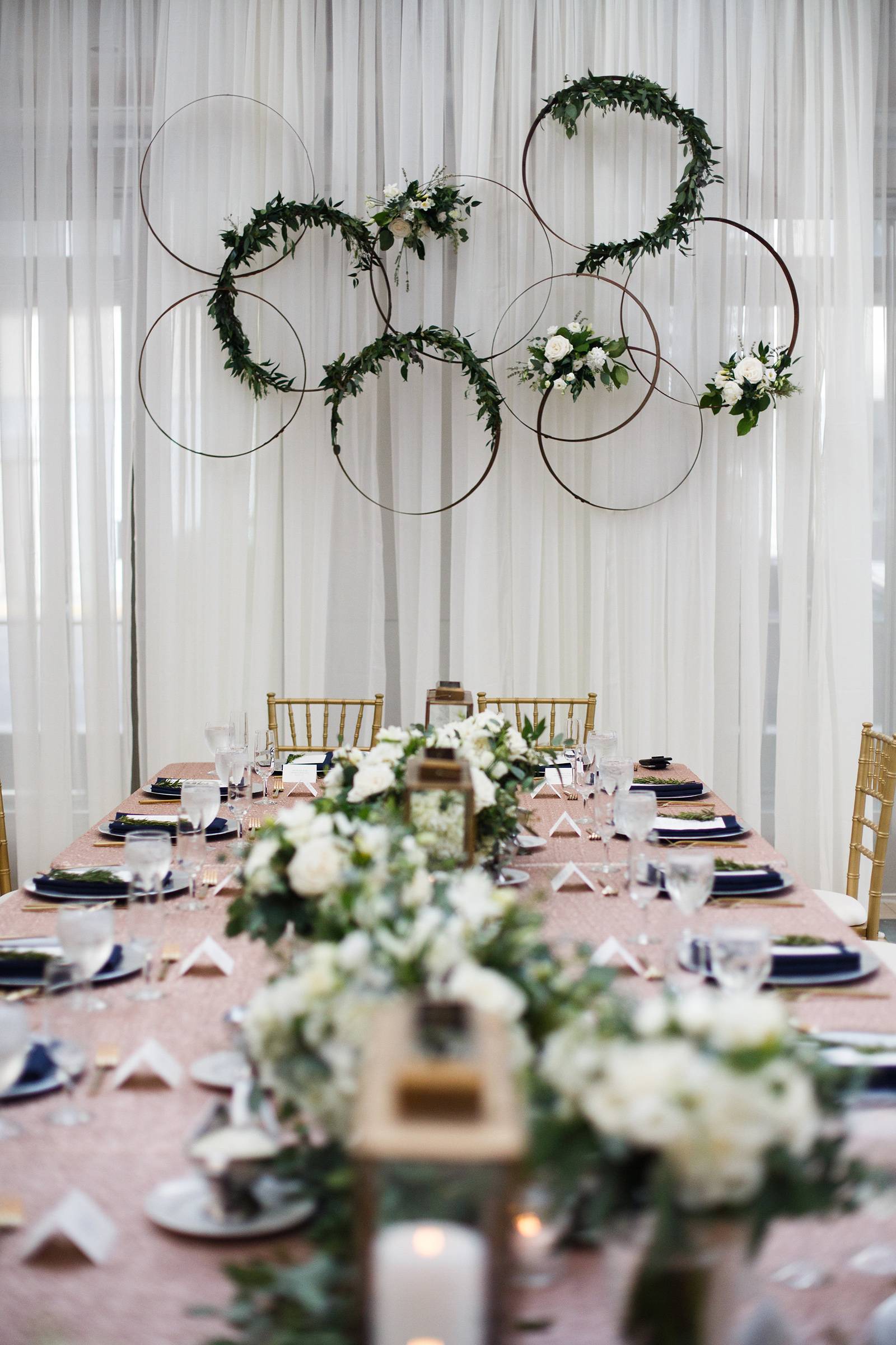 hanging floral arches, flower circles, head table, kings table, white drapery