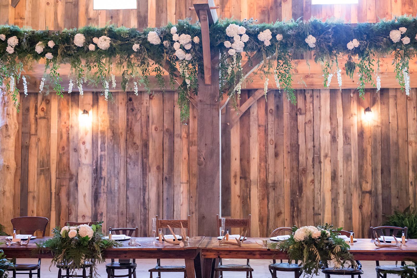barn wedding reception venue, hanging floral flowers, greenery, head table