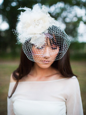 bride wearing a white fascinator with netting