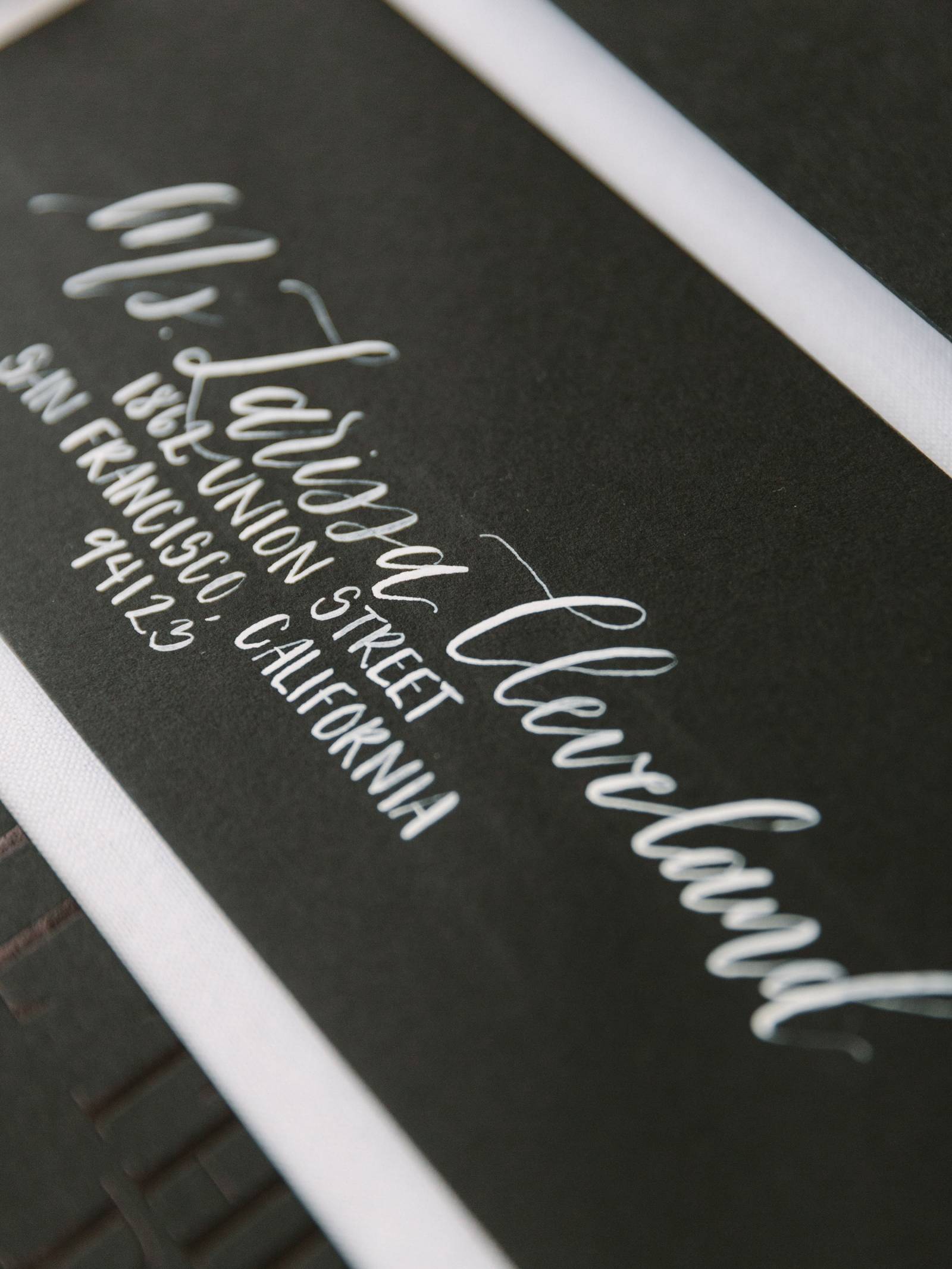 black envelope strip with guest name and address in white