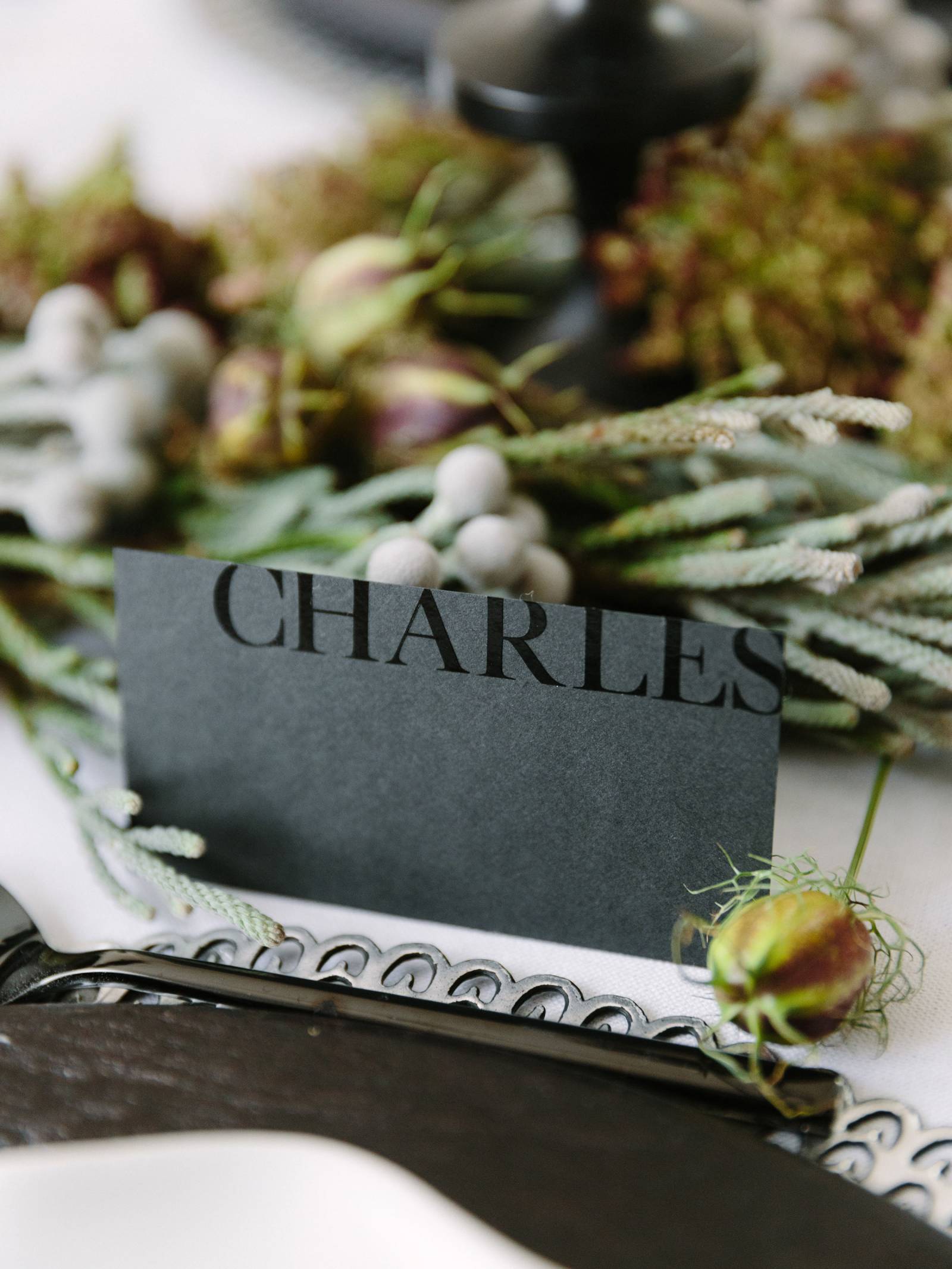 Gray name card with guest name in glossy black ink