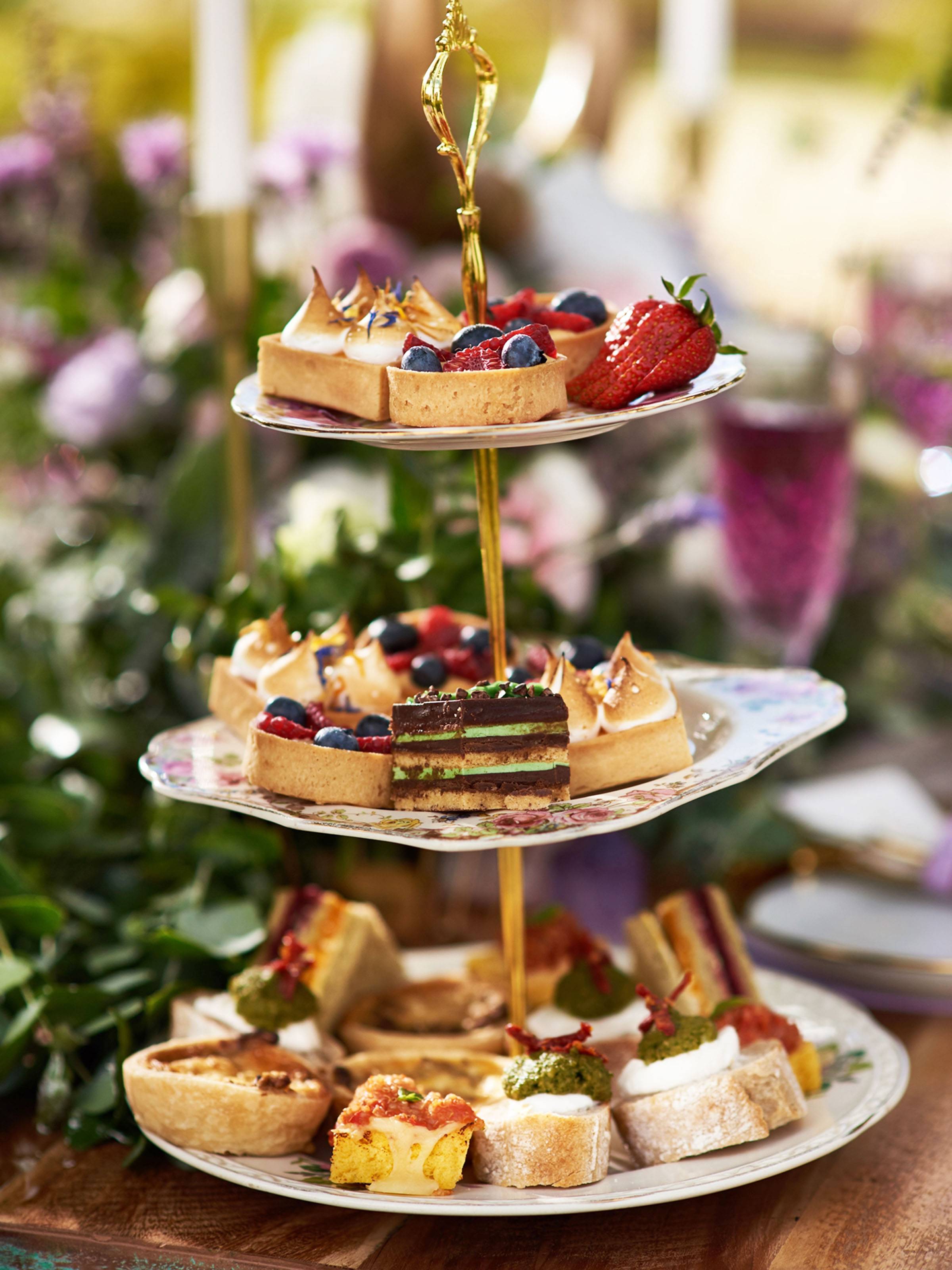 Three tiered dessert tower with fruit, tarts, meringue pastries