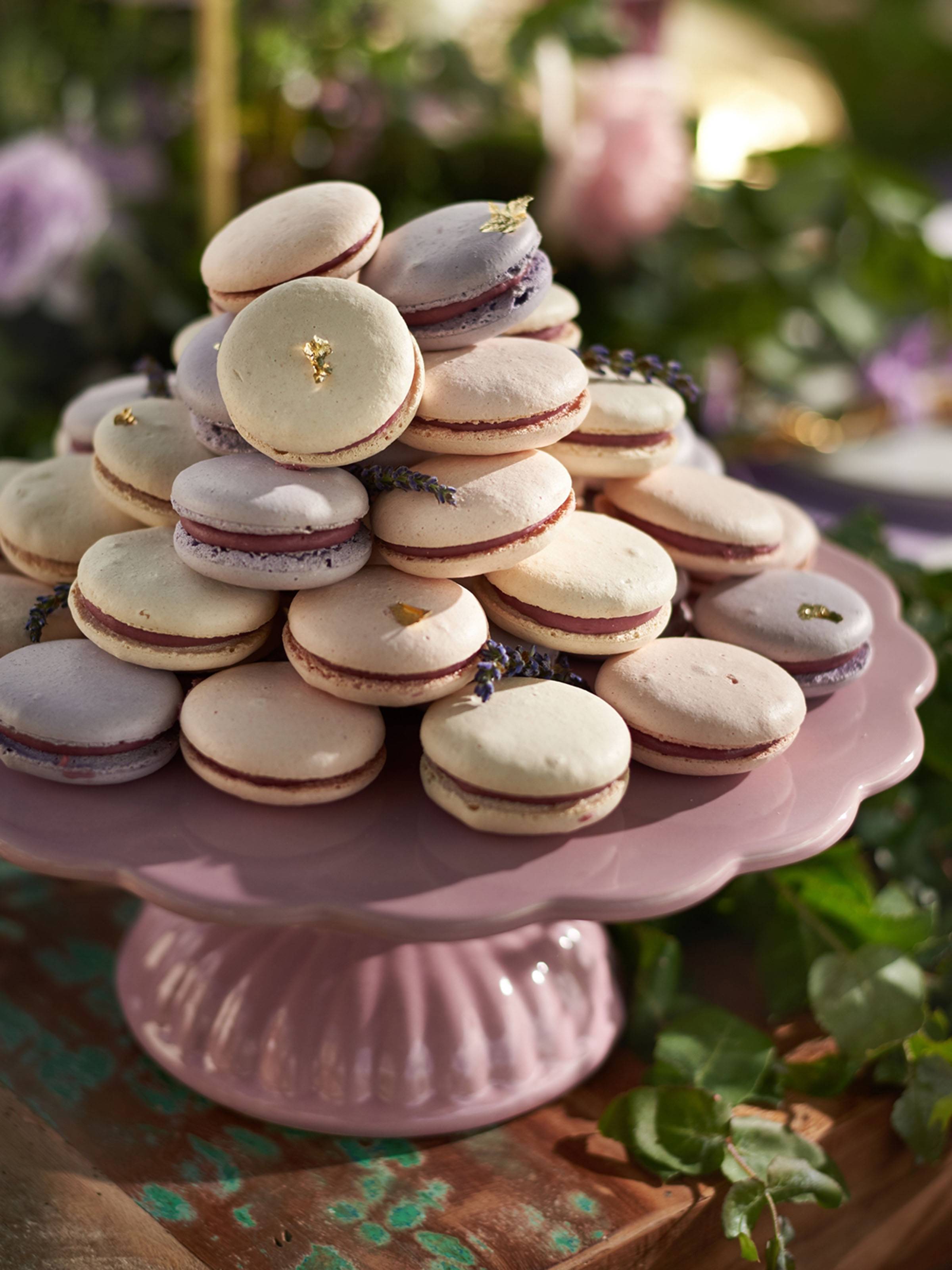 Ivory and lavender macarons on a mauve cake stand