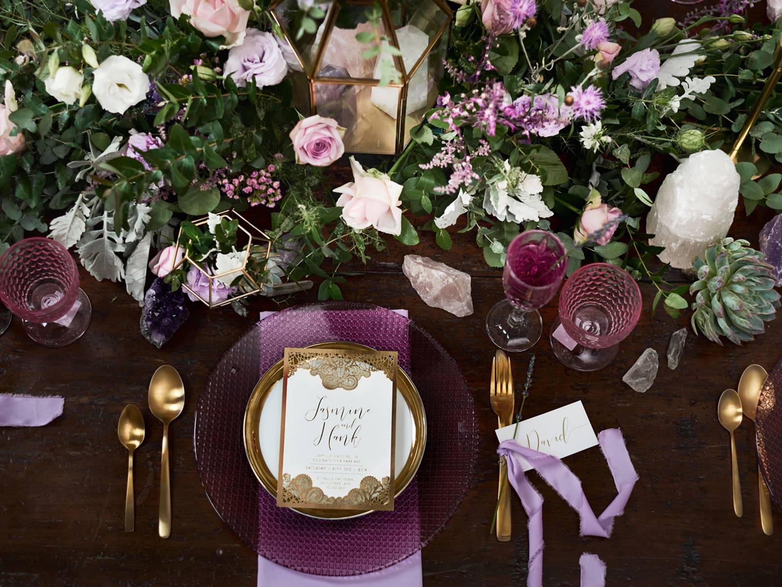 Tablescape of lavender and pink flowers with greenery with purple charger, white and gold plate