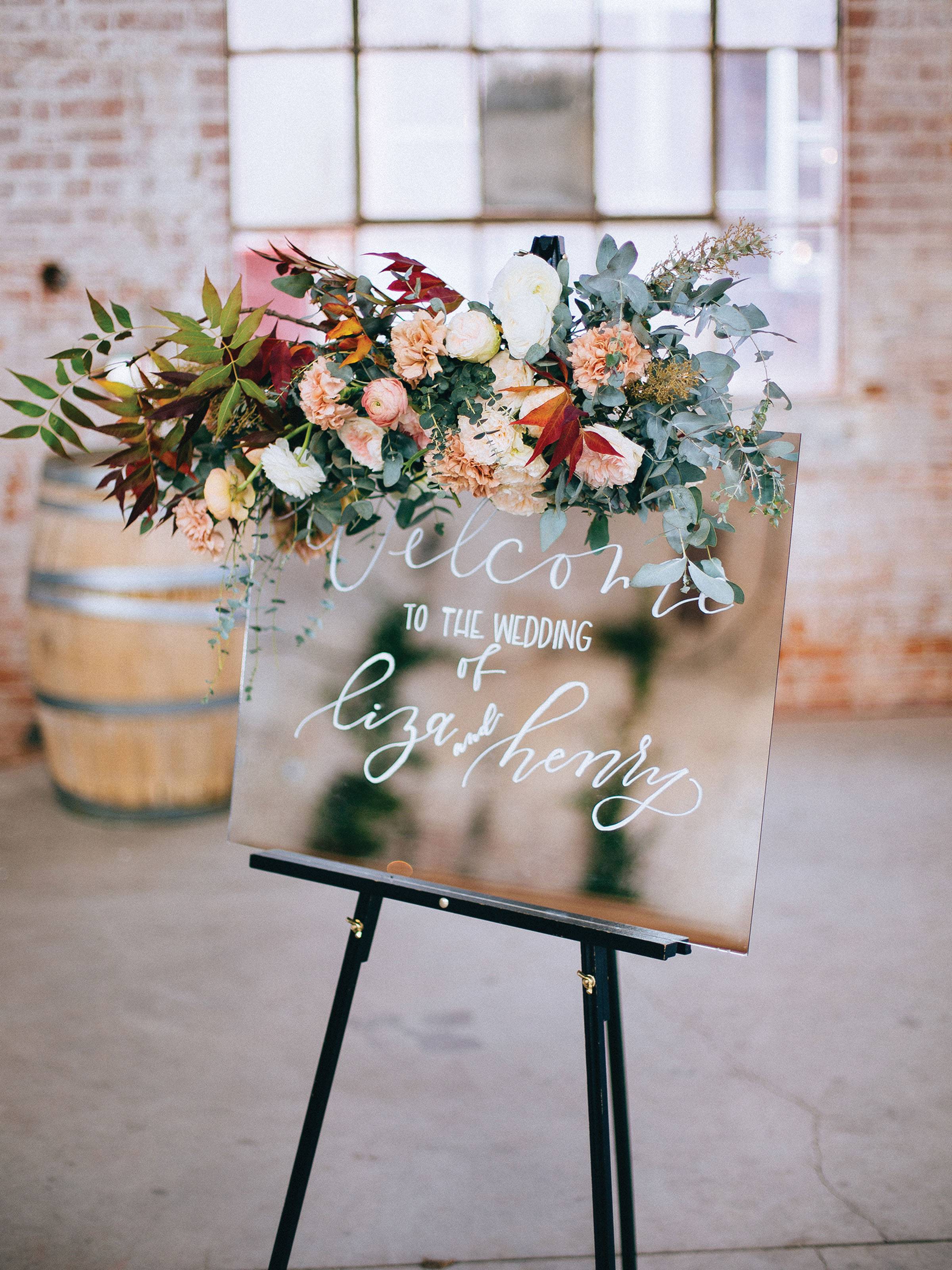 Mirrored ceremony sign with fall florals