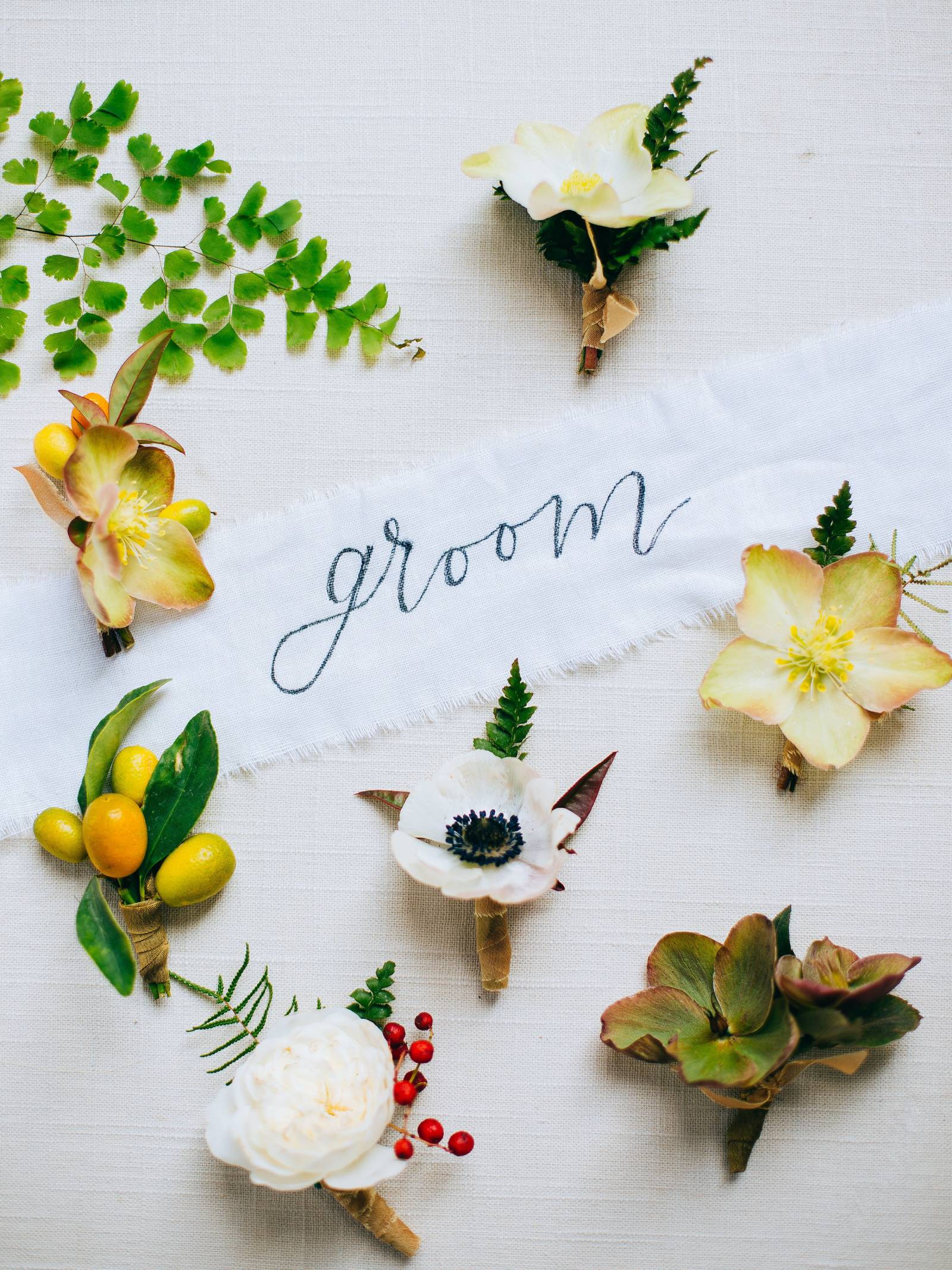 Yellow boutonnieres of citrus, succulents and blooms