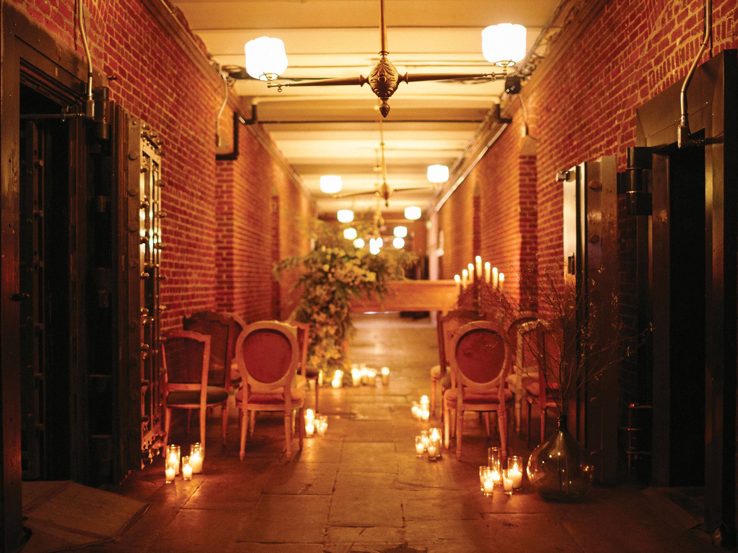 Brick corridor set-up for a ceremony with floral draped altar, seating and candles