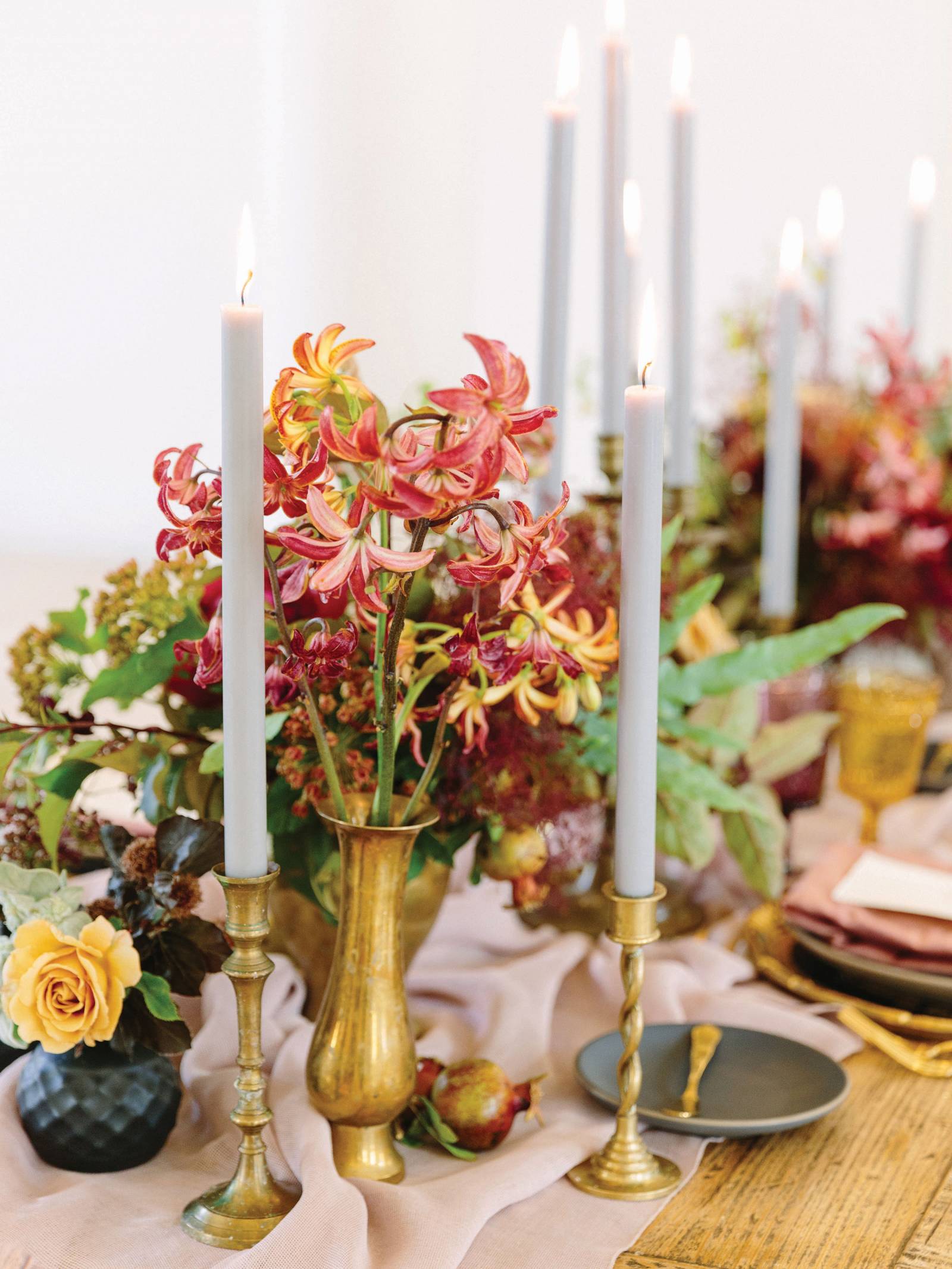 Fall toned flowers with white tapered candles and gold holders