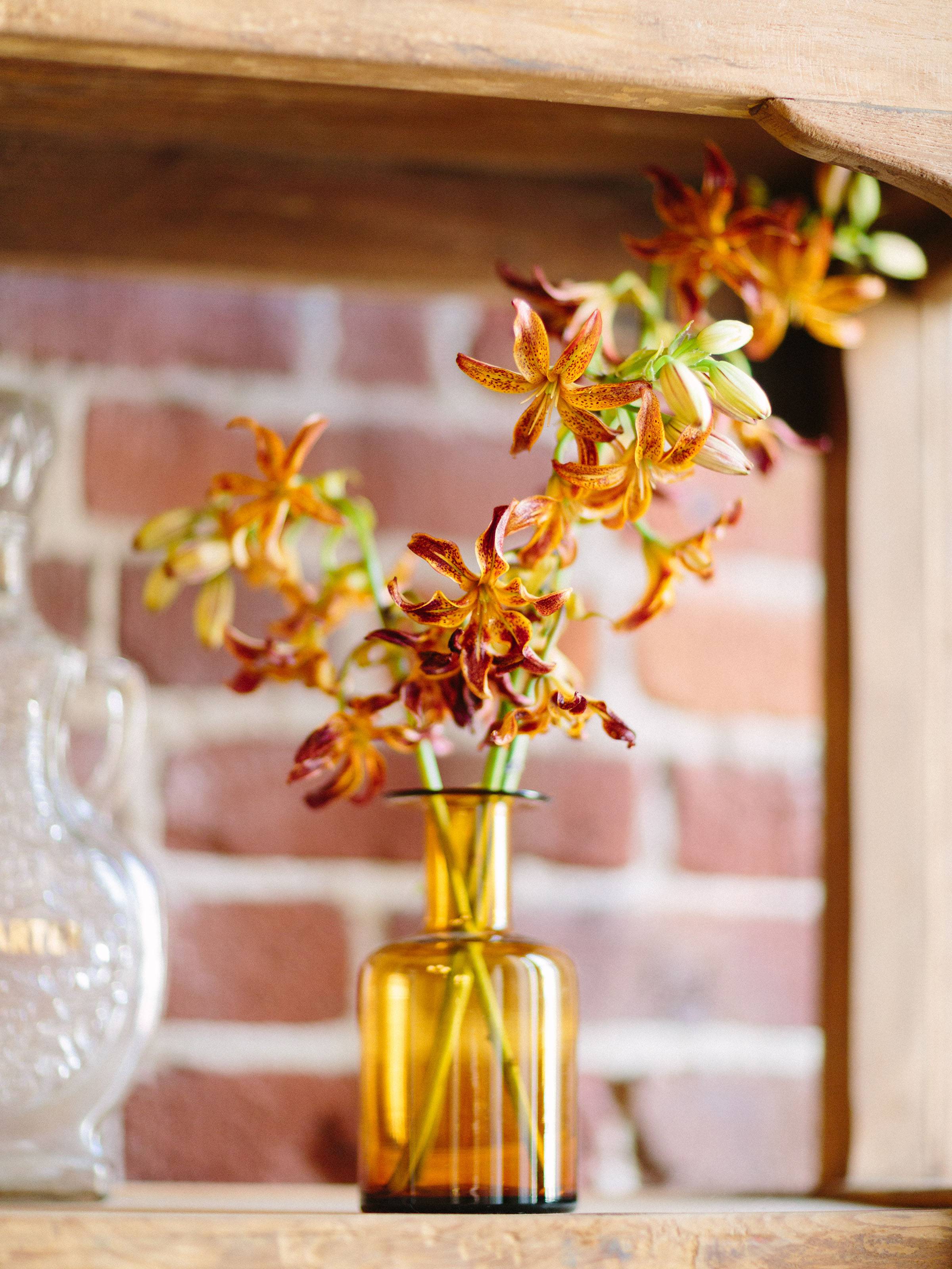 Yellow retro glass vase with yellow and red orchid stems