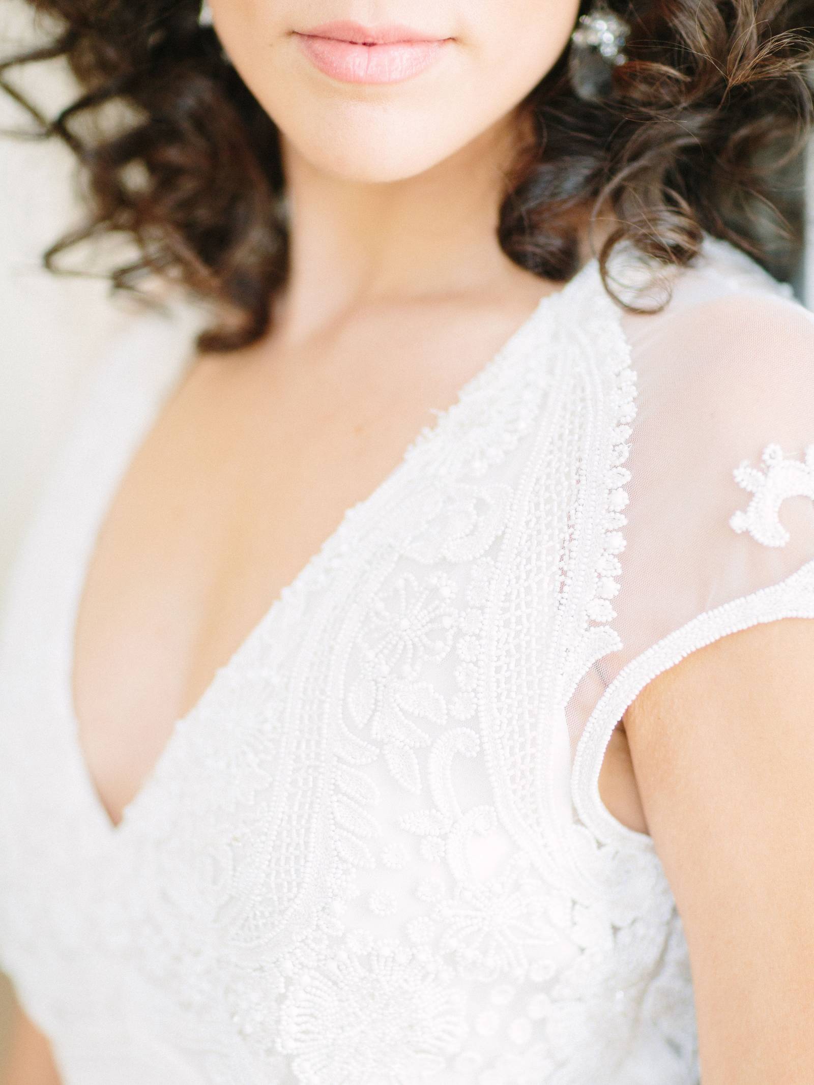 Close-up of a bride in a white wedding gown with deep v-neck