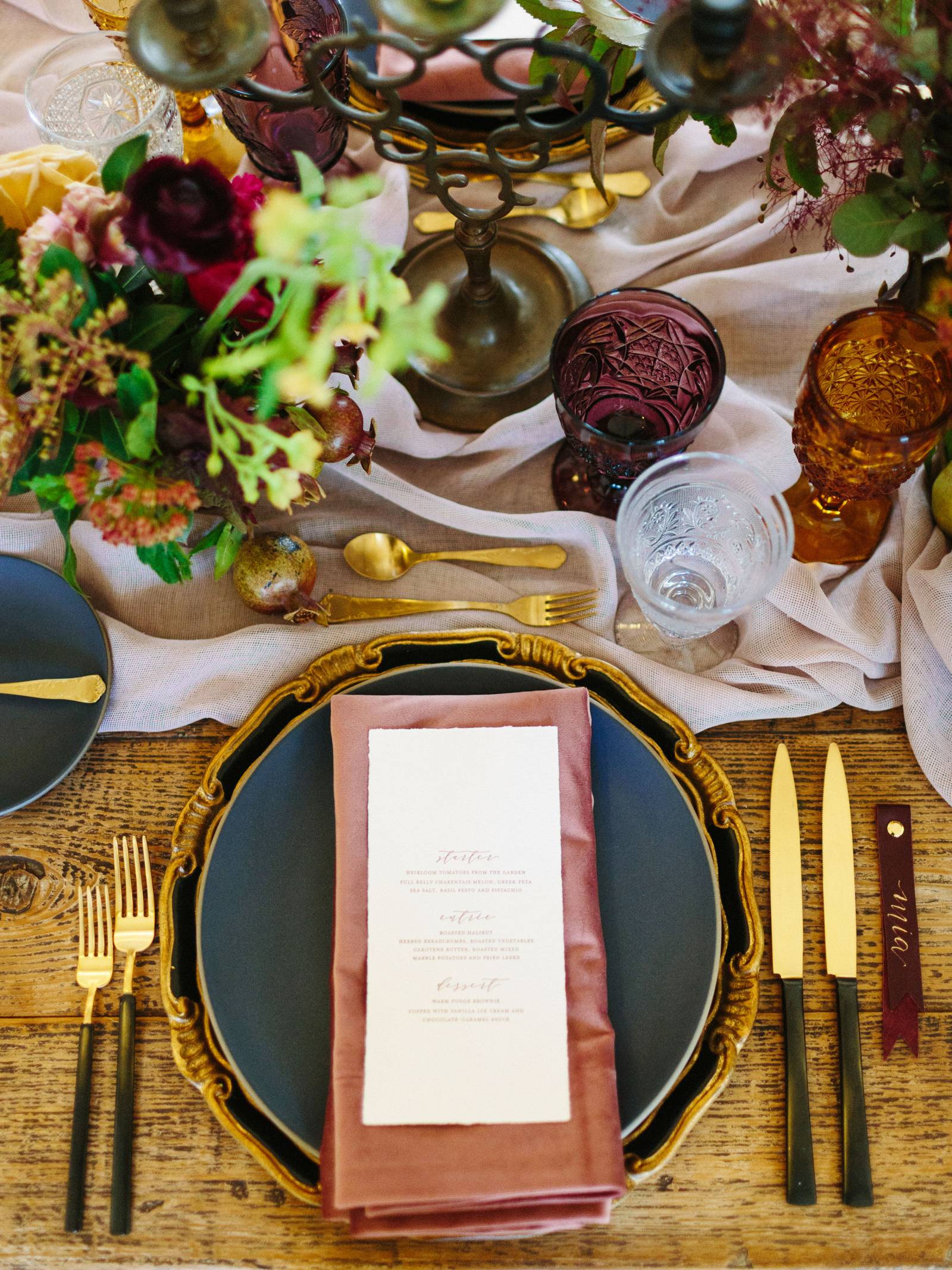 Black and gold flatware and charger with purple and gold cut-glass goblets