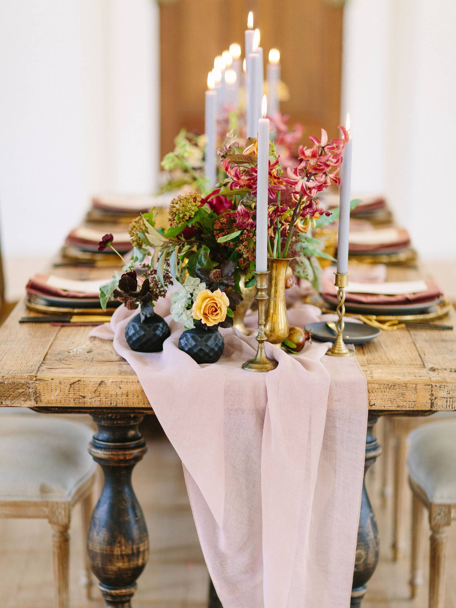 rustic table with fall flowers, black plates and vases and lavender tapered candles