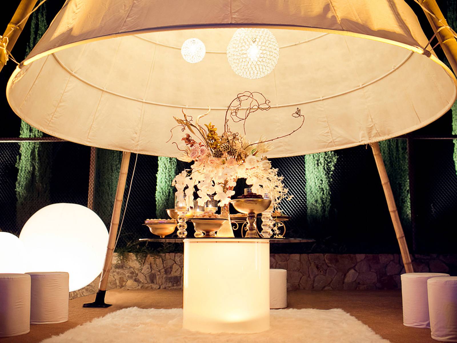 Dessert table with lush gold decor under a giant canvas Tepee