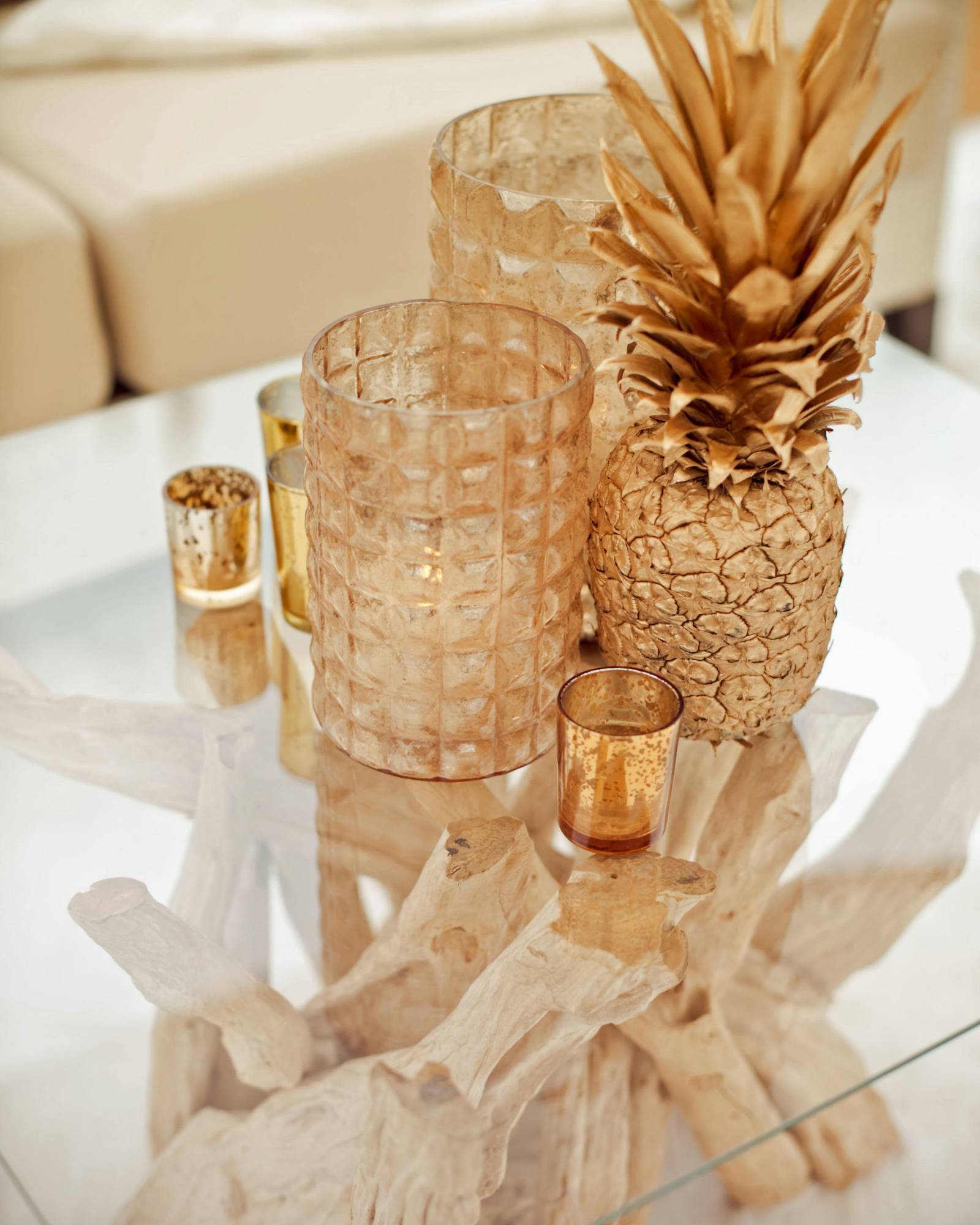 Grouping of gold sprayed pineapple, gold candle sleeves and votives