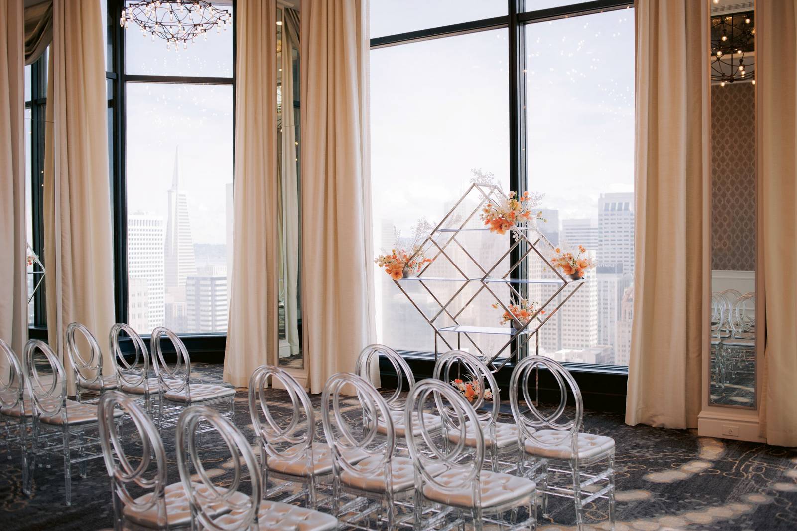 Ceremony setting with acrylic chairs and geometric chrome ceremony prop