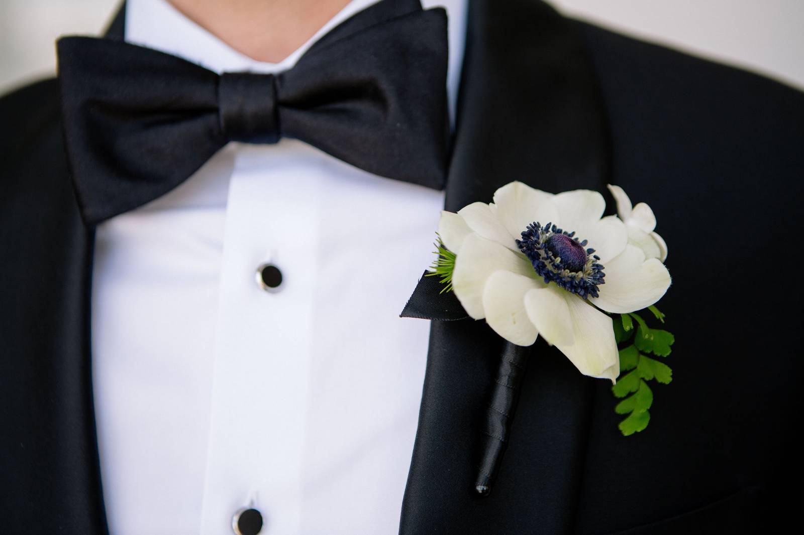 grooms boutonniere of anemone and fern branch