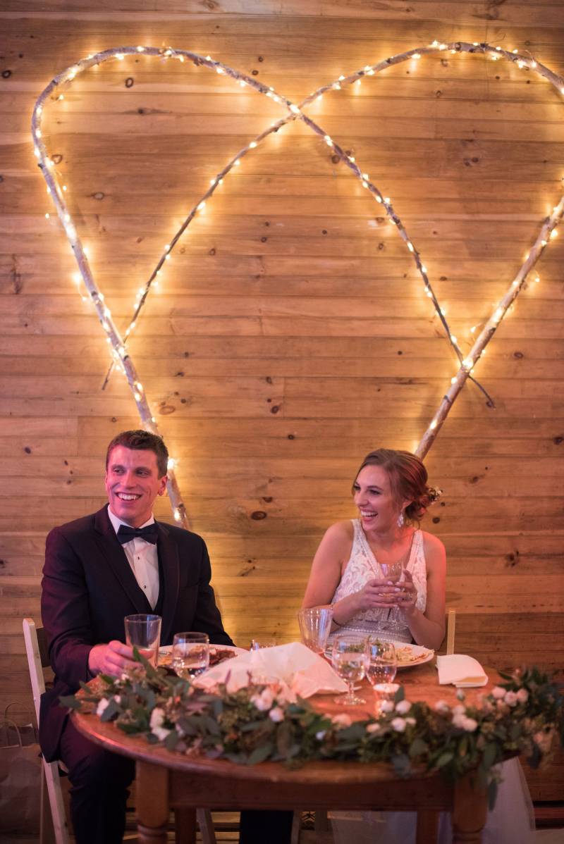 Sweetheart table lighting backdrop idea for rustic barn venue
