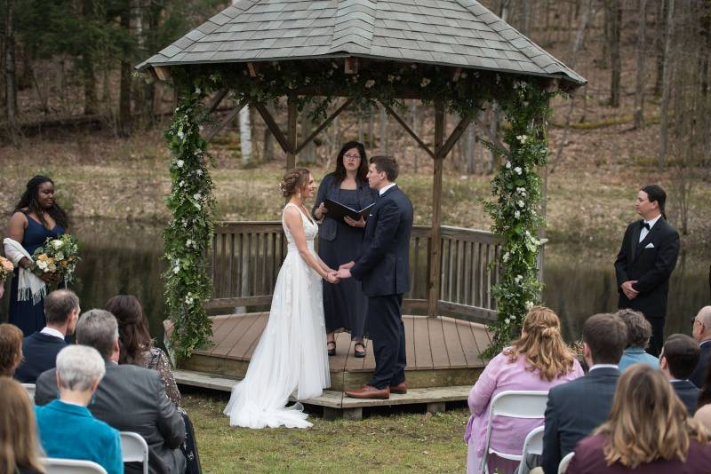 Bride and groom exchange vows under gazebo at Sleepy Hollow during spring Vermont wedding