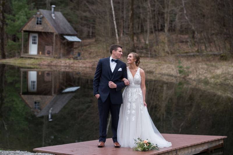 Portrait of bride and groom in front of the pond at Sleepy Hollow Inn in Vermont on spring wedding d