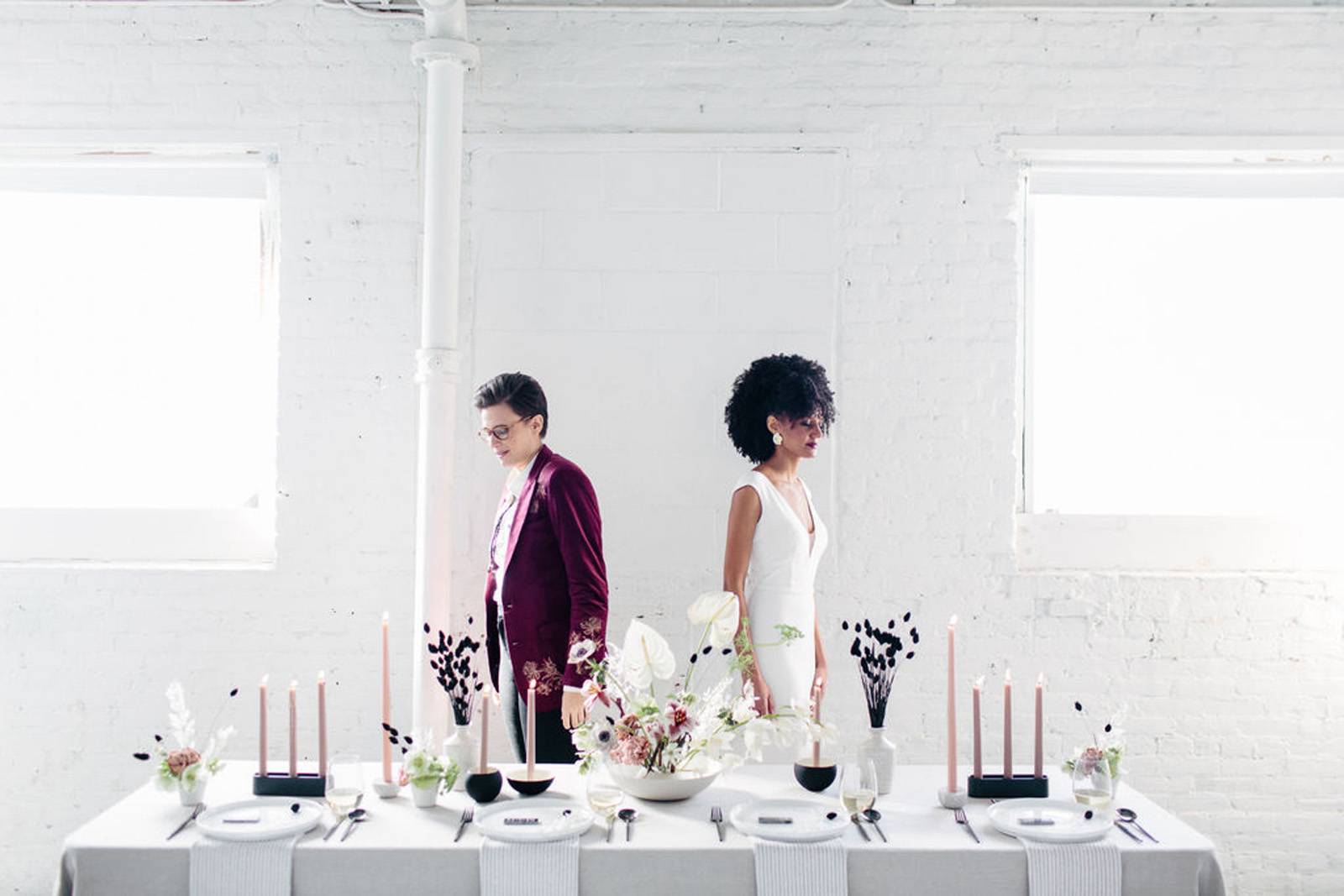 Brides standing behind modern romantic table setting for first look