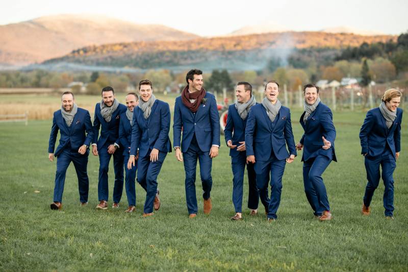Groomsmen wearing navy blue suits and scarves for fall wedding at Boyden Barn