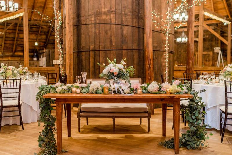 Sweetheart table with floral garland at the Inn at the Round Barn Farm